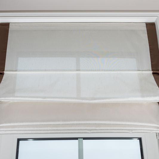 Roman blind gathered in soft horizontal fabric folds above a window