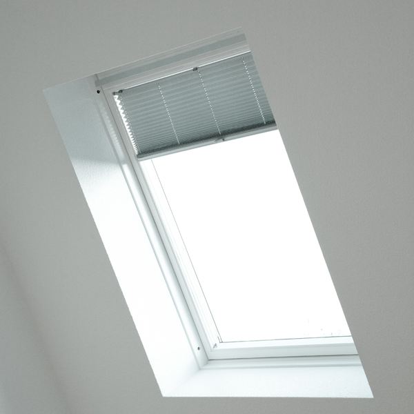 Blind fitted into a sloped roof window against a white ceiling