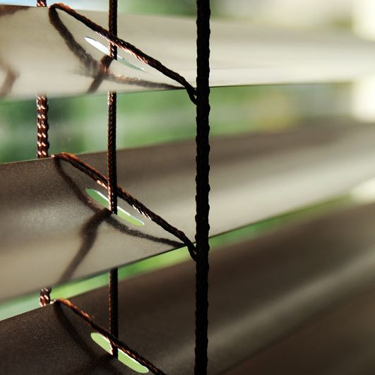 Close detail of venetian blind slats tilted to filter daylight